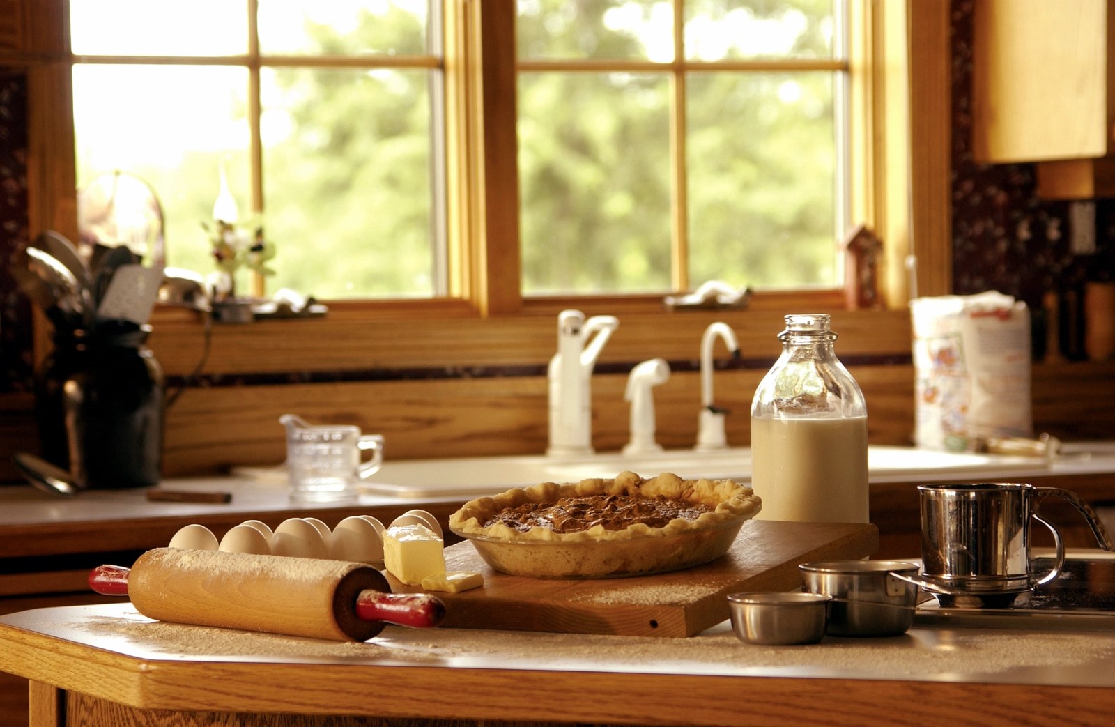 Warm traditional kitchen with timber window frames and baking laid out on the counter in afternoon light